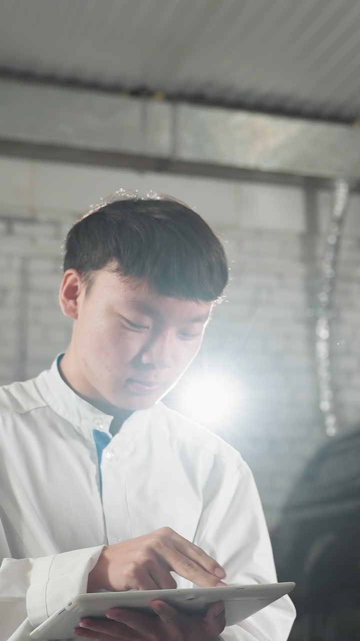 실험실 기술자들은 자동차 엔진에서 스파이너 사용을 시연하는 엔지니어를 관찰합니다. 기계 작업장에서 동의 표시로 고개를 끄덕이면서 산업 작업 공간은 차량, 도구 및 장비를 배경으로 특징으로합니다.