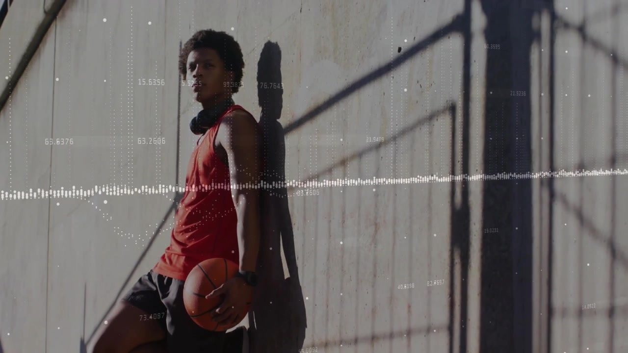 After training male athlete gripping orange basketball and sipping water bottle and surveying court