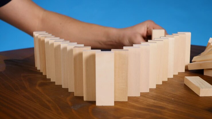 Domino effect concept with wooden blocks