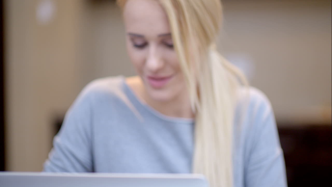 mujer joven sonriente trabajando en una computadora portátil
