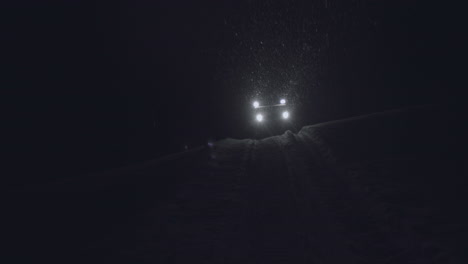half-track driving in the night in jotunheimen in norway. the half-track has skies in front. its night and the snow are falling. filmed on a gimbal in 4k. this is a slow-motion clip.