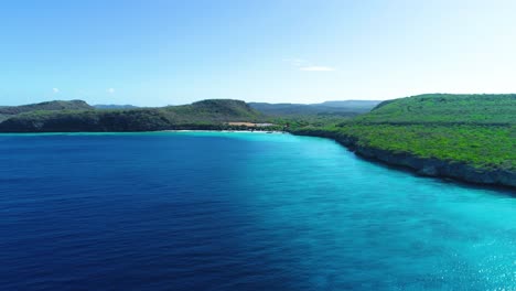 rising aerial drone above crystal clear deep blue caribbean waters of curacao