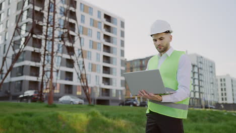 male engineer using laptop at a construction site