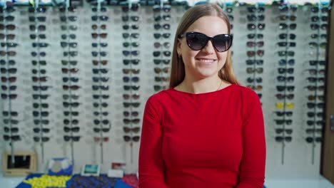 young woman buying sunglasses. cheerful woman buying glasses in optician shop