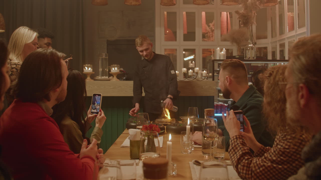 Chef preparing flambe for a group in a restaurant