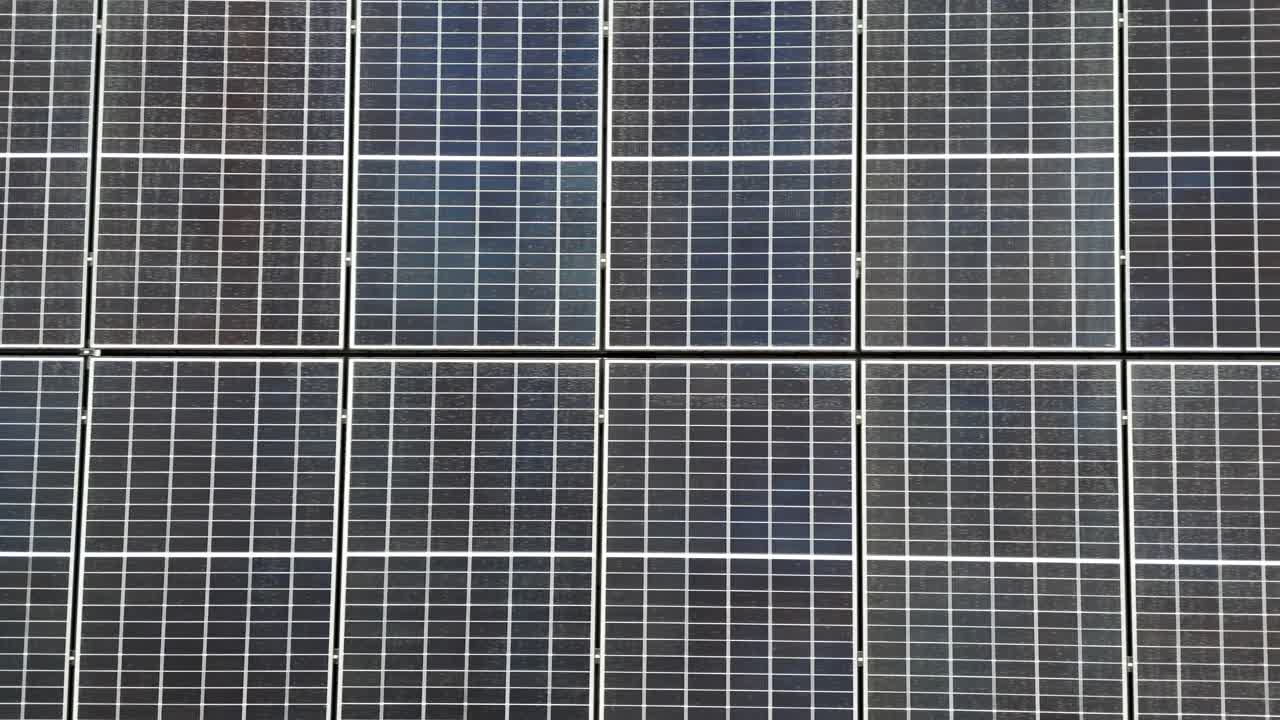 Solar panel units on top of roof producing green energy during sunny summer day in USA. Aerial top down flyover close up. Electricity, sustainable, renewable Energy in modern American neighborhood.