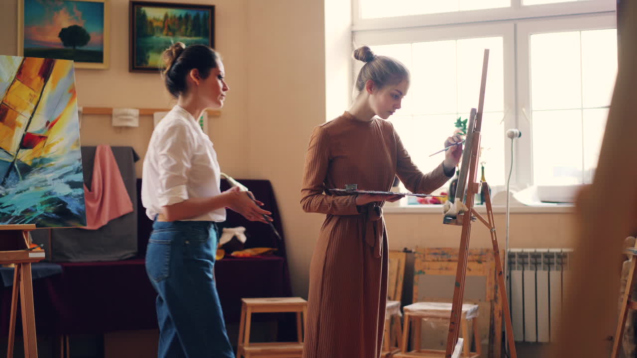두 명의 여성이 미술 스튜디오에서 그림을 그리고 있습니다.