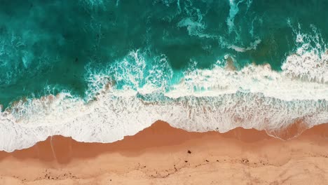 foamy waves on sandy shore of manhattan beach in los angles, california