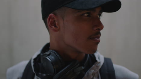 close up portrait attractive mixed race street dancer man looking at camera turns head thinking contemplative wearing trendy fashion