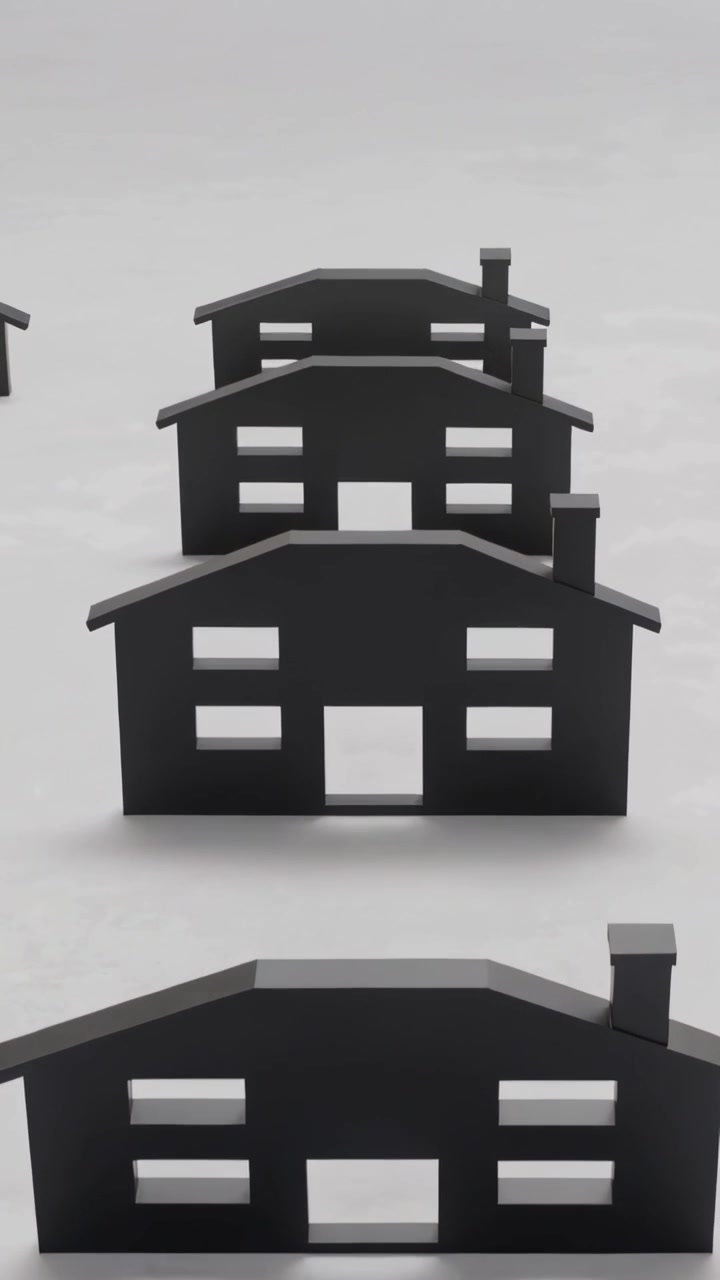 Video vertical: Cámara haciendo zoom, acercando un recorte de casa negra sobre la mesa, revelando una chimenea.