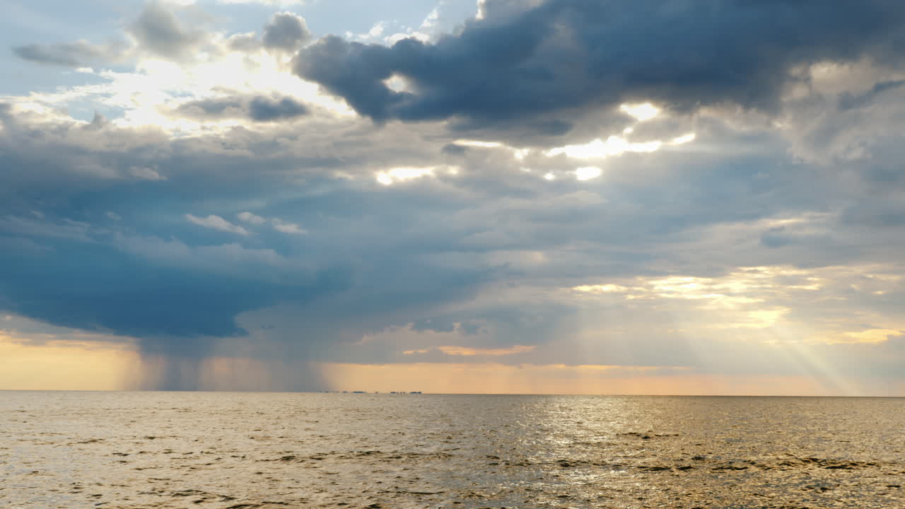 바다 멀리까지 강한 비와 아름다운 광선으로 지는 태양 1