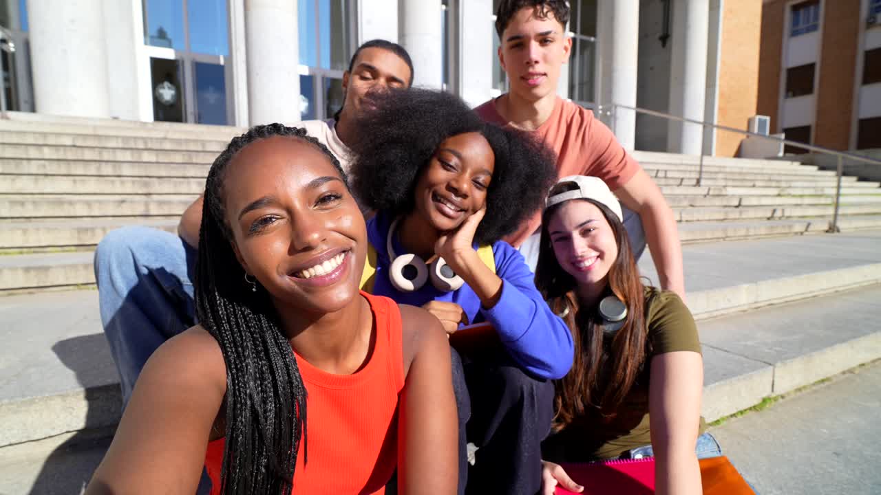 Groupe diversifié d'étudiants prenant un selfie sur les marches du campus