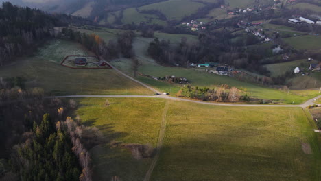 Luftaufnahme-Einer-Von-Kasernen-Umgebenen-Landschaft-Inmitten-Einer-Hügeligen-Landschaft-Mit-Sonnenstrahlen