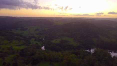 Aerial-view-of-hills-in-a-tropical-forest-valley-at-sunset