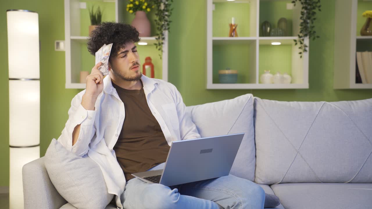 Young thoughtful man with money in hand.