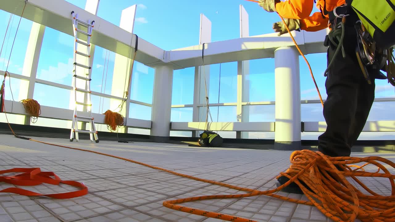 고층건물을 오를 준비를 하고 있는 로프 액세스 작업자, 건물에 장비를 갖춘 앱자일러 작업자, 낮은 각도