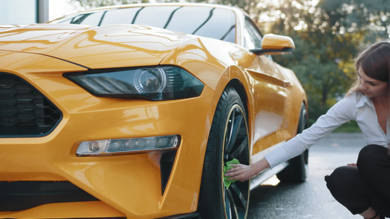 mujer lavando un coche deportivo amarillo