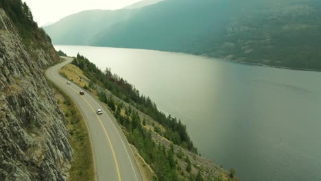 Langsamer-Schwenk-Aus-Der-Luft,-Der-Autos-Zeigt,-Die-Durch-Den-Slocan-Lake,-Kanada,-Fahren