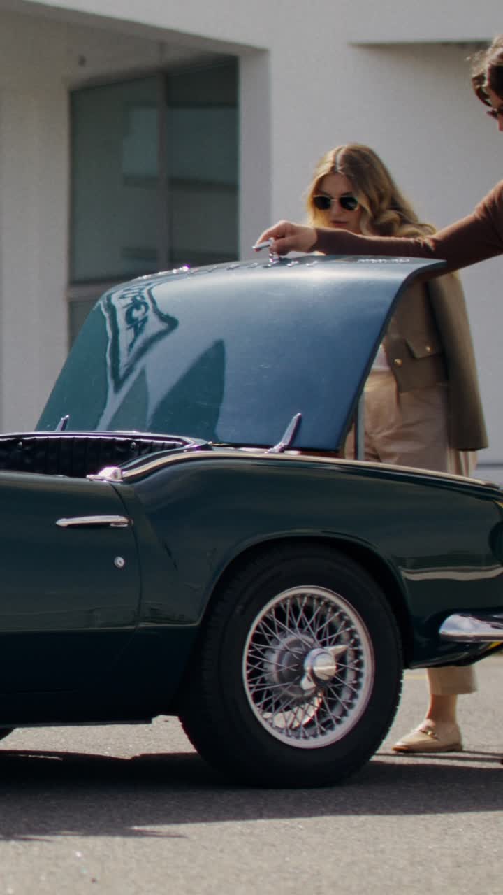 Couple getting into a vintage convertible car