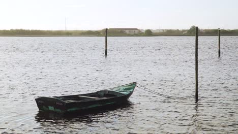 4k-Holzboot-Vor-Anker-In-Ria-De-Aveiro,-Altes-Boot,-Das-Sich-Auf-Der-Flussströmung-Bewegt