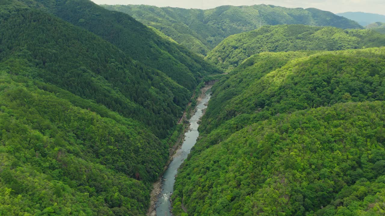 Aerial Landscape of Arashiyama between Forested Mountains of Kyoto Japan, Lush Green Environment
