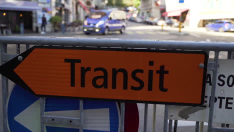 Slow-motion-dolly-of-traffic-transit-sign-with-car-in-the-background