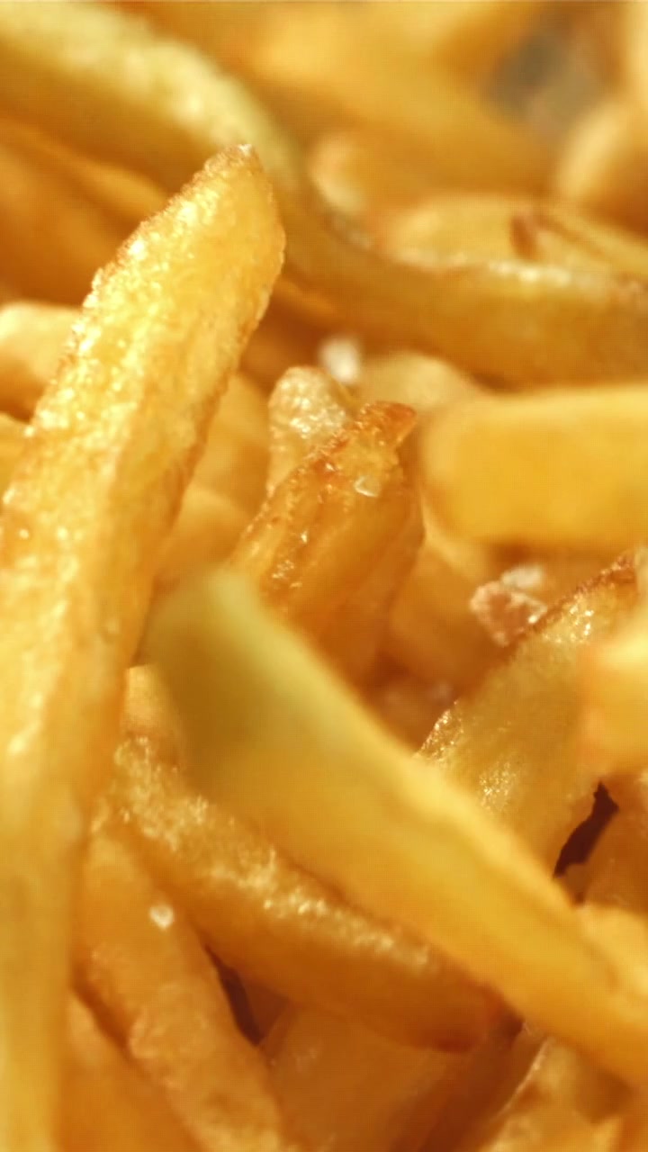 Nærbilde av sprø gylne pommes frites med salt