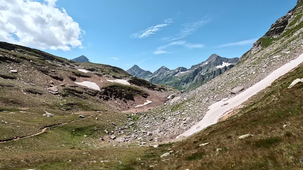 Sweeping alpine view of rocky slopes, sparse snow patches, and glacier remnants in Alpe Veglia Natural Park, Italian Alps