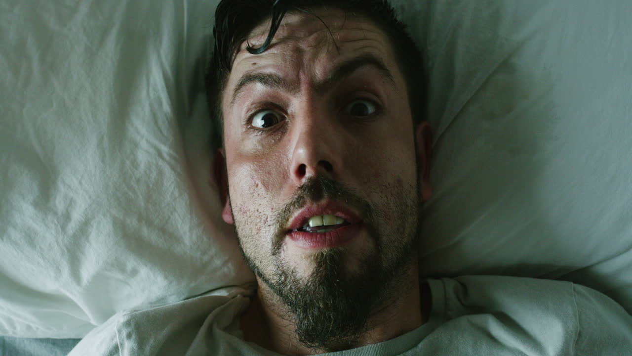 un hombre en el dormitorio, insomnio tiene una pesadilla en la cama