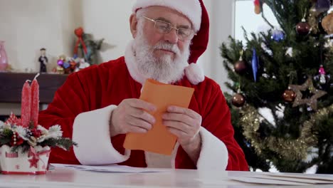 santa escribe una carta y la pone en un sobre.