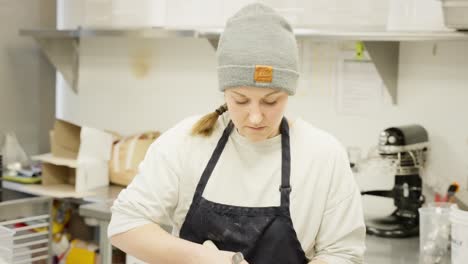 baker kneading dough in a bakery kitchen