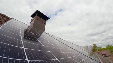 timelapse of solar panels reflecting sky and clouds on a suburban roof with bright light