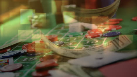 game cards, chips, and cash falling on roulette table and squared lights on the foreground in casino