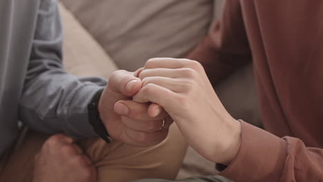 two unrecognizable men holding hands of each other