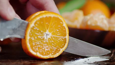 men's hands cut mandarin on a cutting board into pieces.