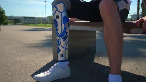 person with prosthetic leg sitting on a park bench