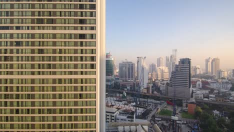 Timelapse-glass-skyscraper-building-with-cloudy-sky-timelapse-in-the-background-in-summer-daytime