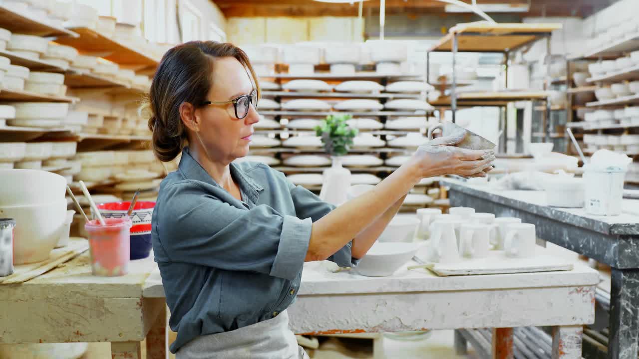 alfarero femenino mirando la copa moldeada 4k