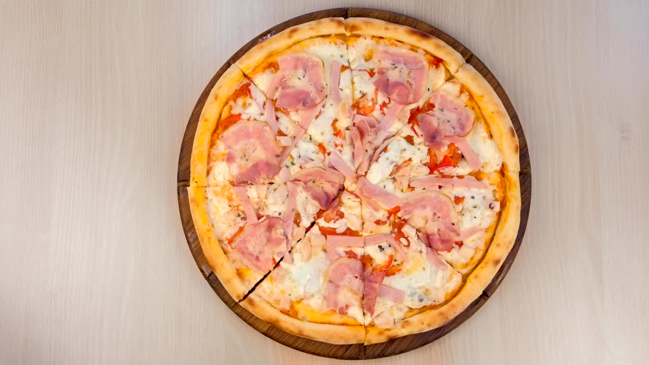 테이블 위에 나무판에 베이컨과 치즈를 은 피자.