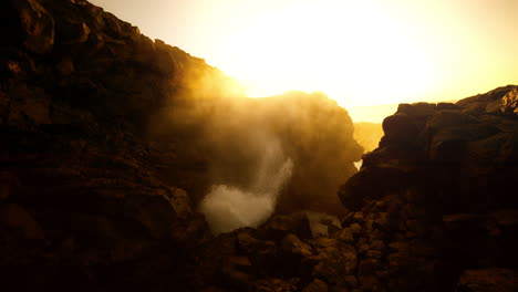 powerful waves crashing through coastal rocks at sunrise