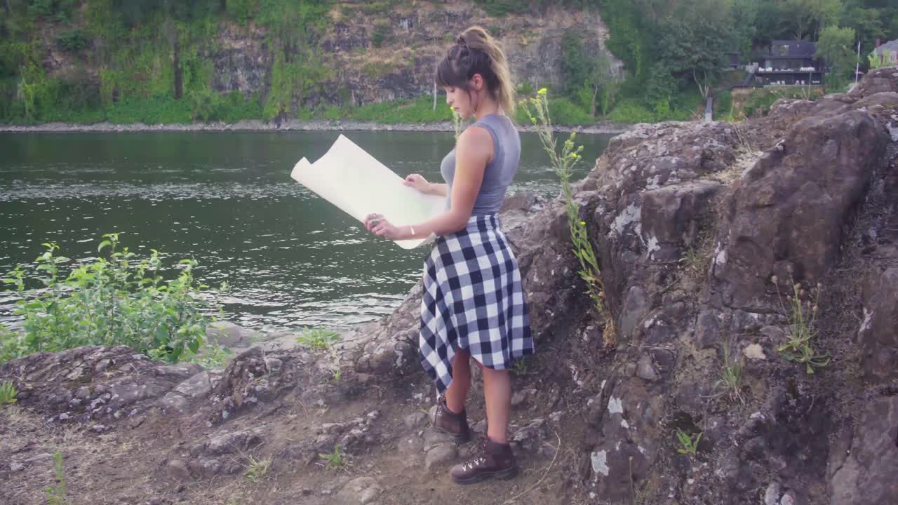 공원을 탐험하는 동안 지도를 보고 있는 귀여운 힙스터 소녀