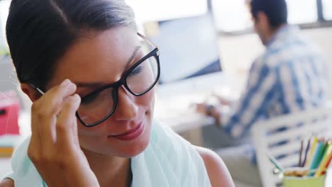 Business-executive-holding-spectacles-in-office