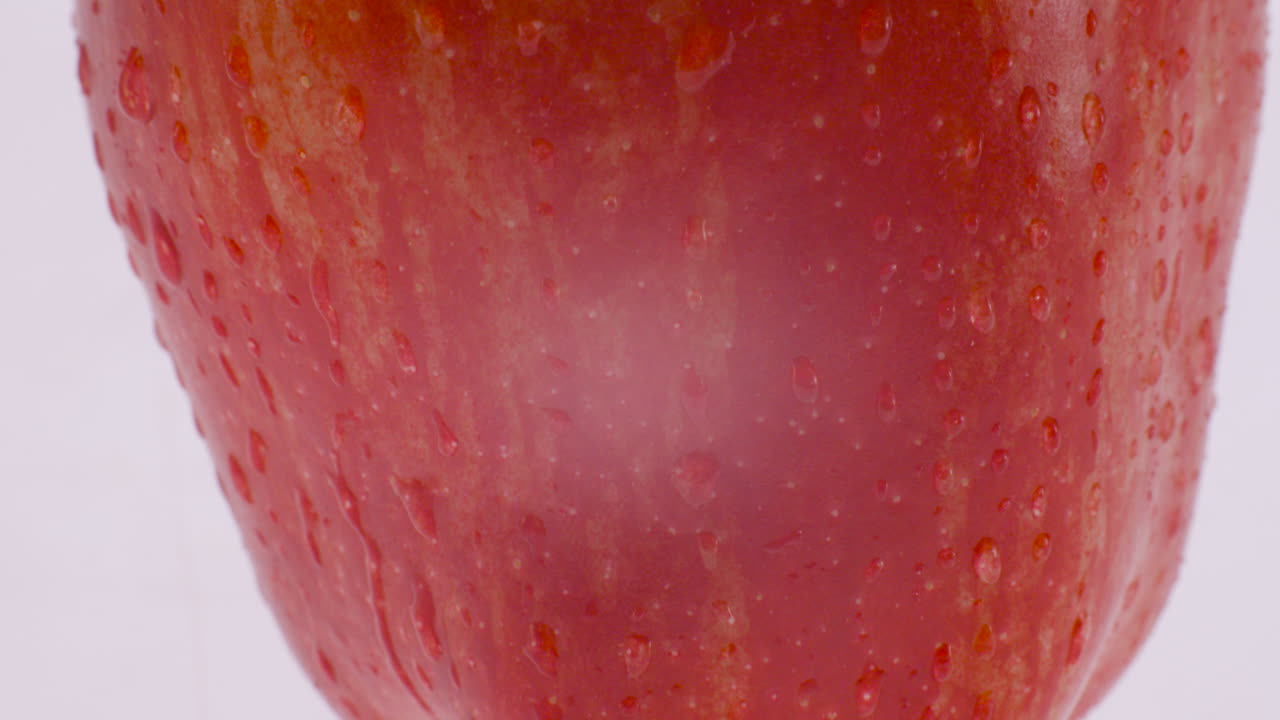 primer plano de una manzana roja con gotas de agua sobre ella