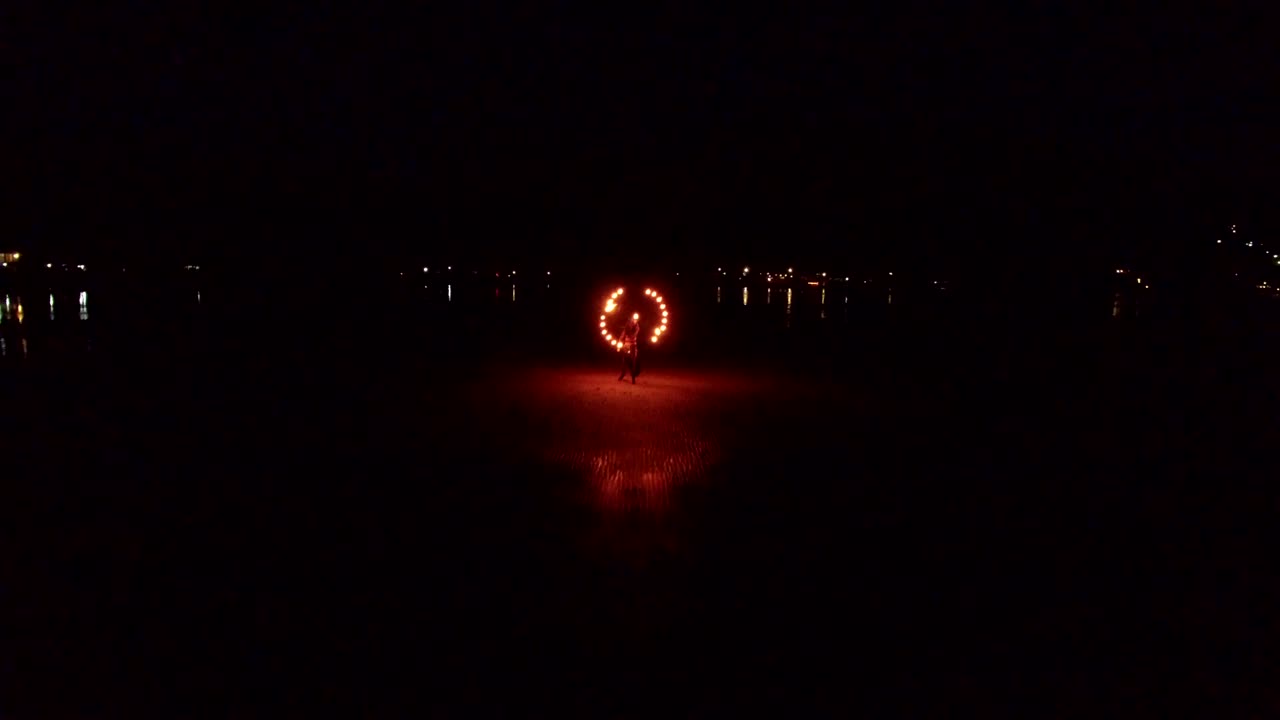 해가 지는 모래 해변에서 춤추는 불 쇼