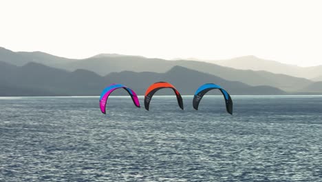 three kiteboarding kites flying through the air, vast open tropical ocean, tropical vacation, no people, mountains in background, slow motion, afternoon soft light