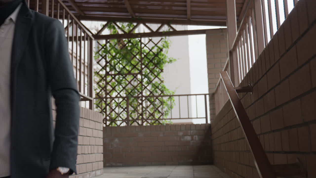 Confident African man walks down bright hallway with poised stride, relaxed shoulders, steady gaze, smart style, business vibe, clean corridor lines, urban mood, progress and purpose in motion