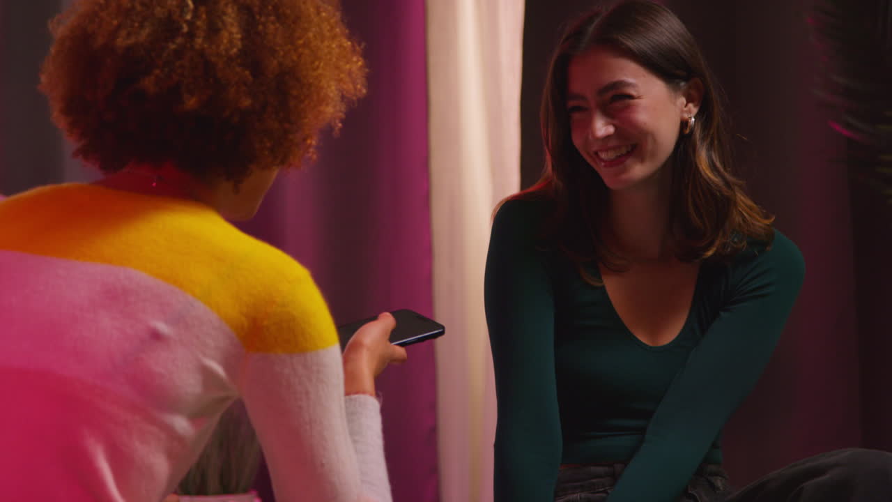 dos mujeres teniendo una conversación y tomando fotos