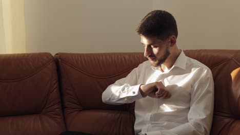 Handsome-groom-man-fixes-his-cuffs-on-a-jacket-with-cufflinks.-Businessman