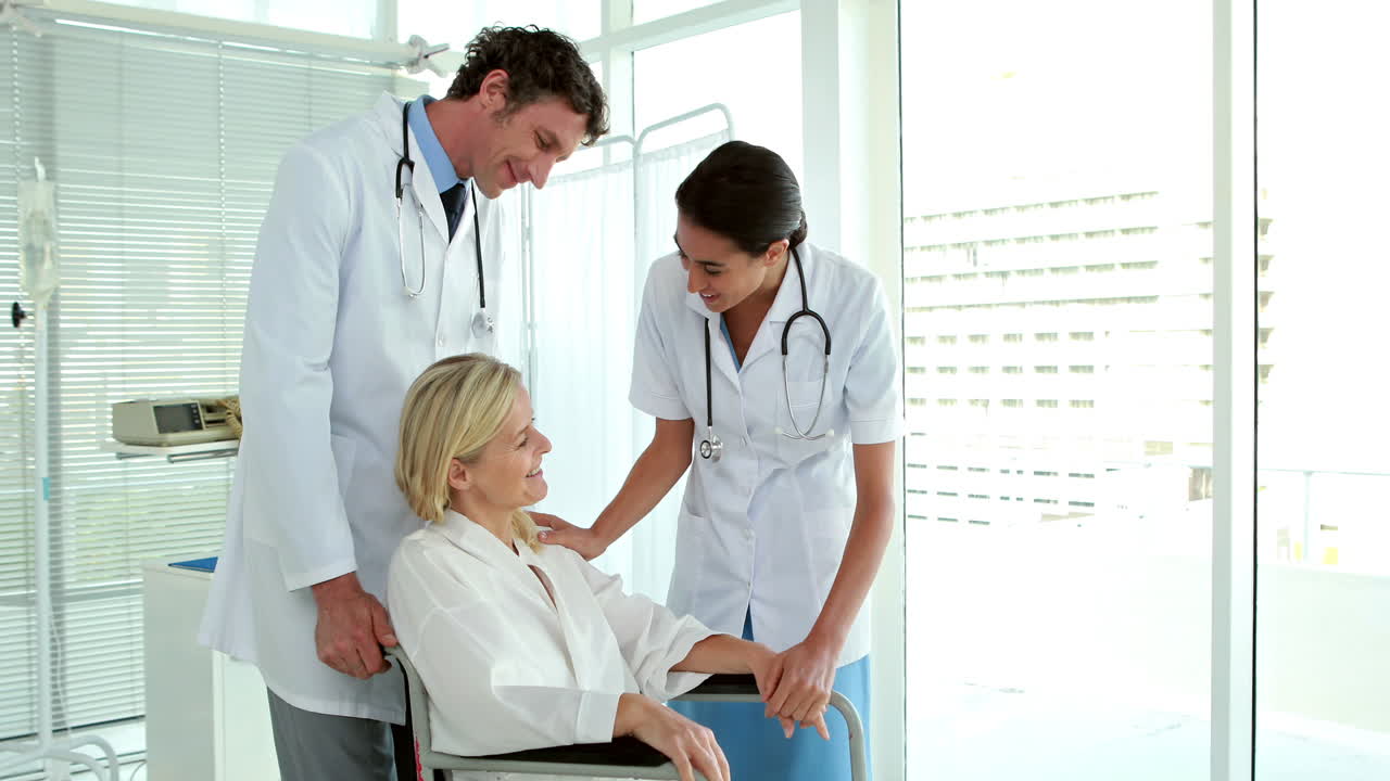 médicos hablando con pacientes en silla de ruedas