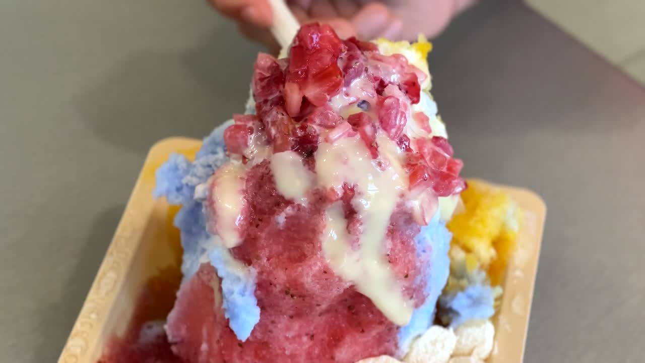 Persone che mangiano delizioso ghiaccio tritato hawaiano; primo piano
